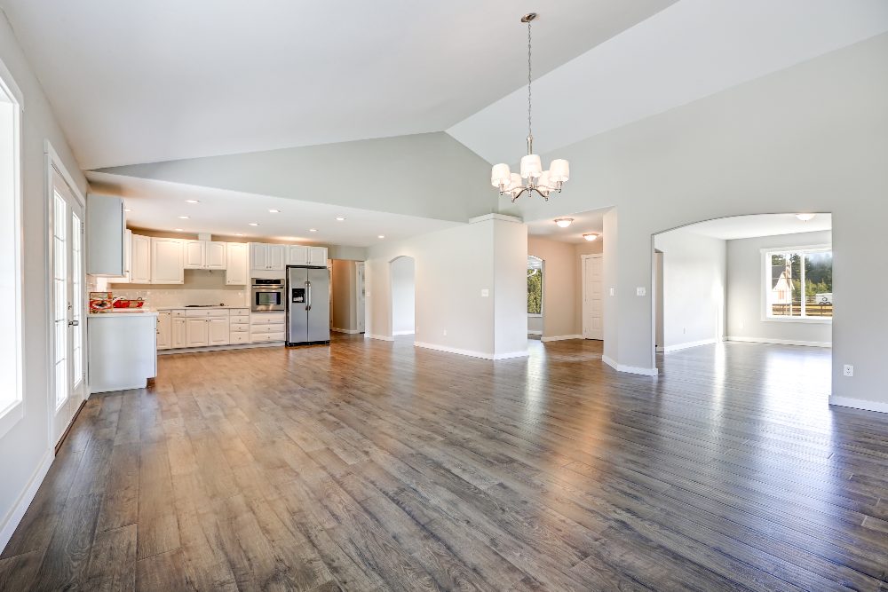 Open concept kitchen and living room with hardwood flooring and pendant lighting